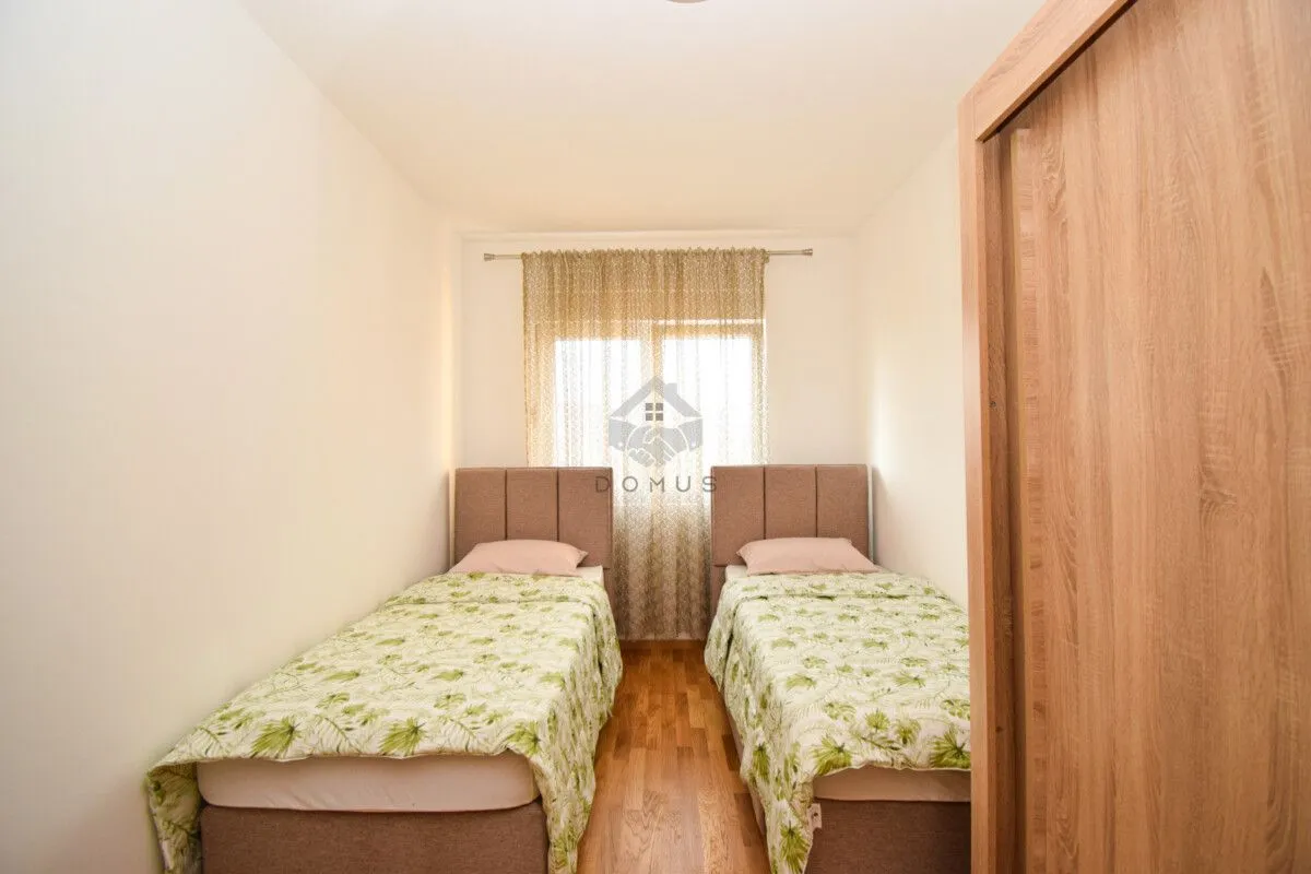 Bedroom with two single beds and a wooden wardrobe.
