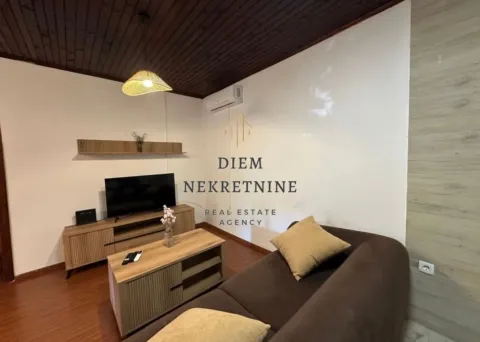 Living room with a sofa, TV unit, and wooden ceiling. - image 4