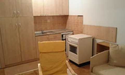 Manja kuhinja sa drvenim elementima, šporetom i sudoperom u sklopu prostorije. - image 4