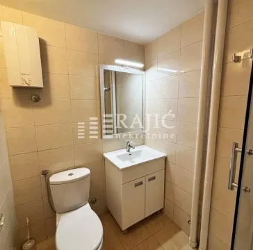 Smaller bathroom with a sink, toilet, and mirror. - image 11