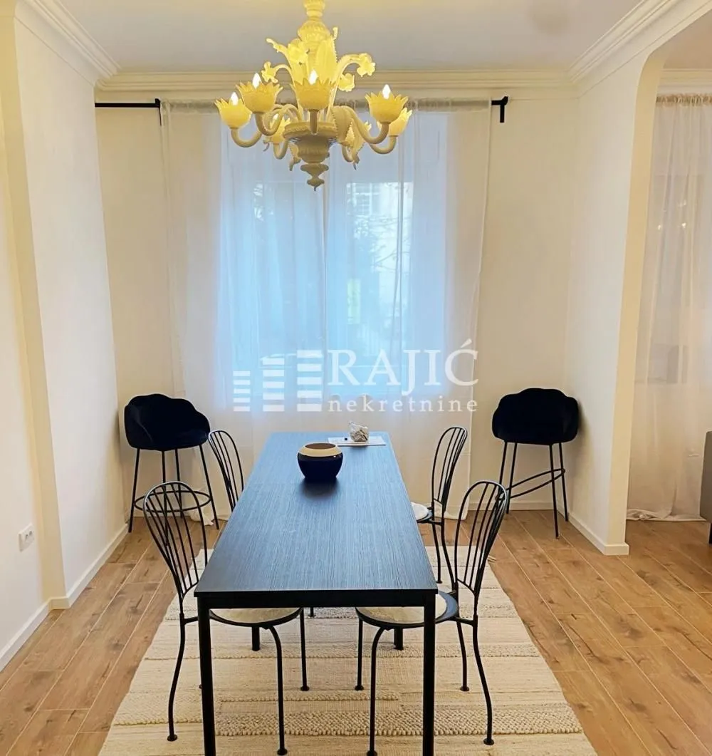 Dining room with a black table, chairs, and a chandelier.