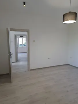 Empty room with light laminate flooring and an open door leading to another room. - image 3