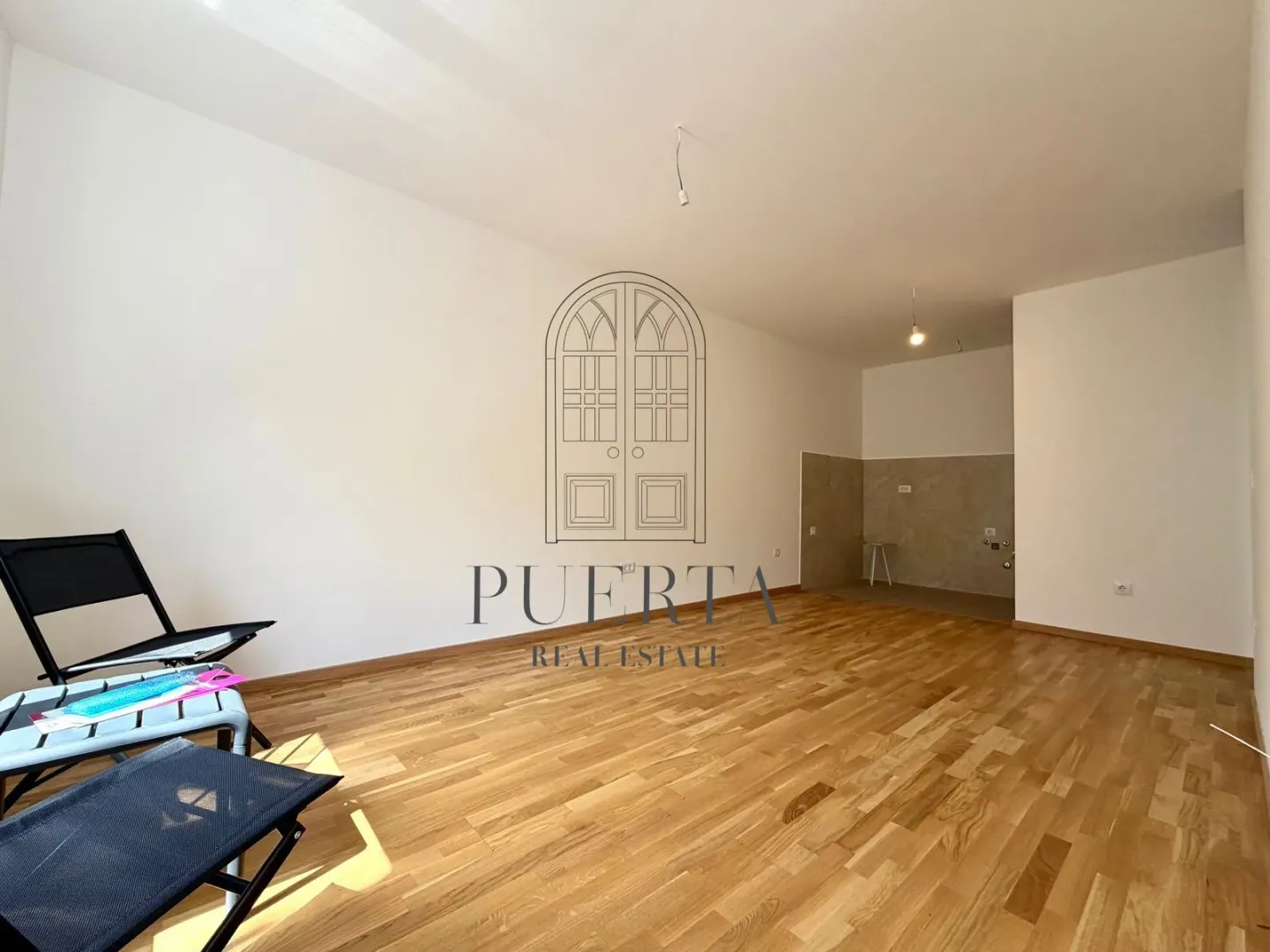 Empty living room with hardwood flooring and an agency watermark.