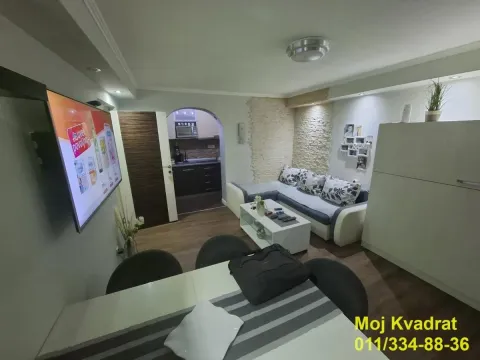 Dnevna soba sa garniturom, TV-om i trpezarijskim stolom u prvom planu. - image 2