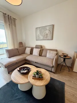Udobna dnevna soba sa ugaonom garniturom, stočićima i ukrasnim detaljima. - image 11