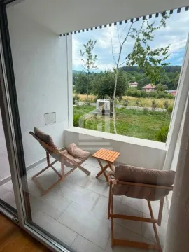 Covered terrace with seating chairs and a view of nature. - image 4