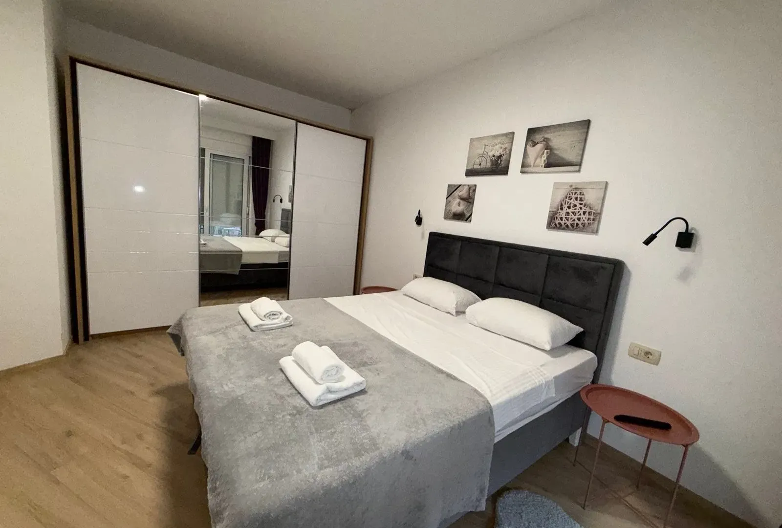 Furnished bedroom with a double bed and a large wardrobe.