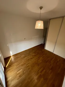 Prazna prostorija sa drvenim podom, ugradnim plakarom i visećom lampom. - image 11