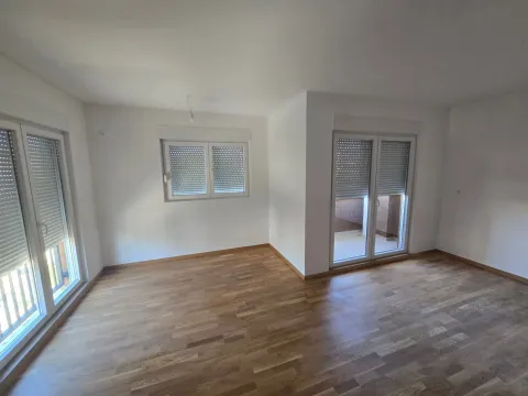 Prazna soba sa parketom, bijelim zidovima i prozorima sa roletnama. - image 5