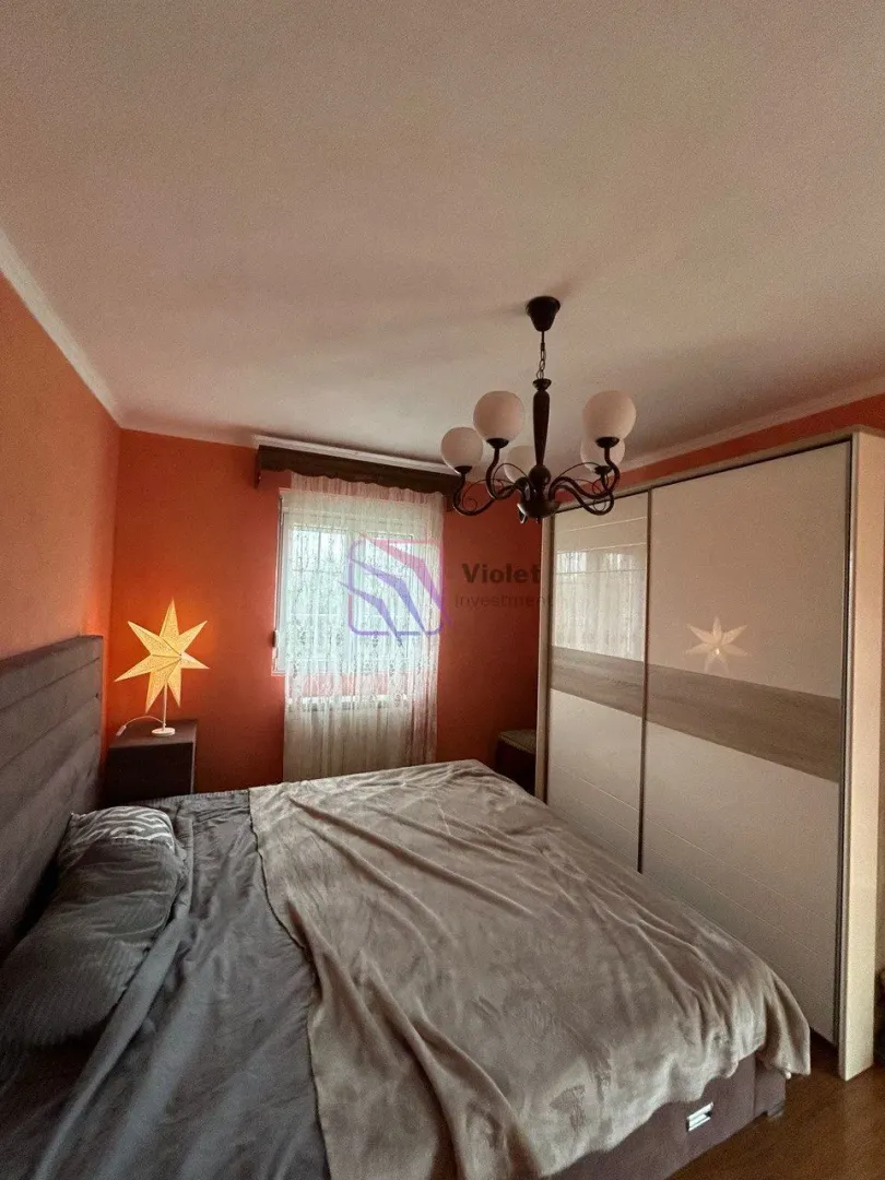 Furnished bedroom with a double bed, wardrobe, and chandelier.