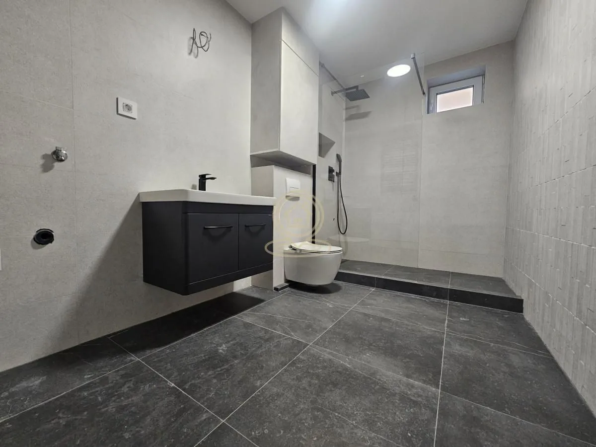 Novoopremljeno kupatilo sa tuš kabinom, umivaonikom i WC šoljom.