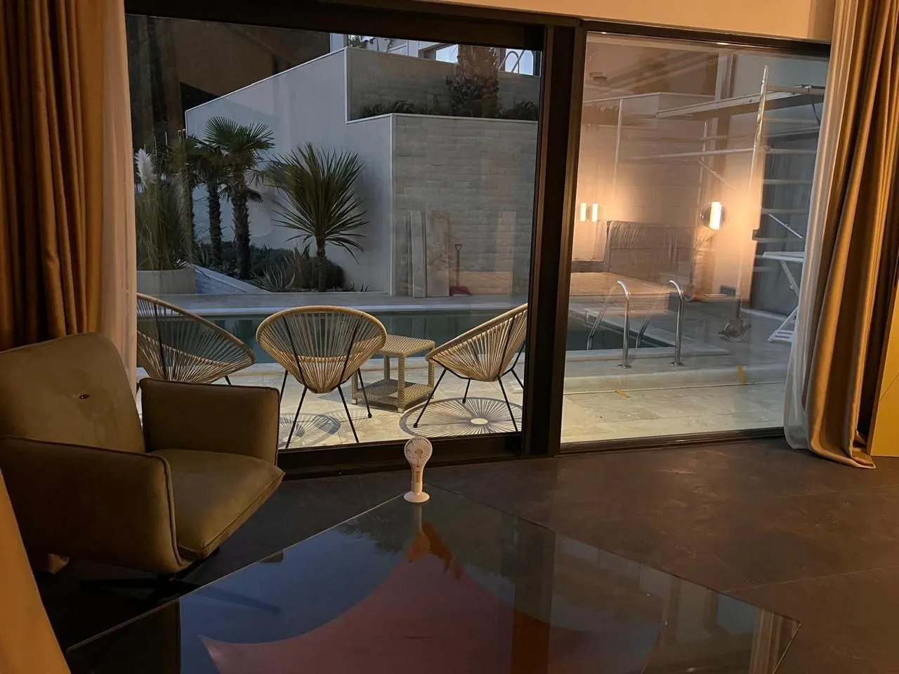 Living room with a view of the pool and courtyard.