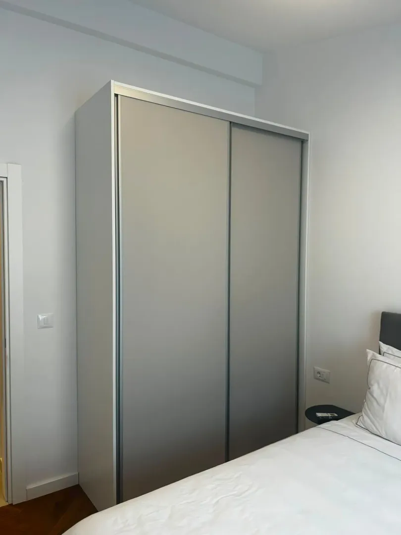 Spavaća soba sa velikim ugradnim garderoberom i bračnim krevetom.