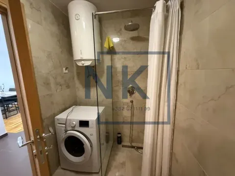 Bathroom with a walk-in shower, water heater, and washing machine. - image 8