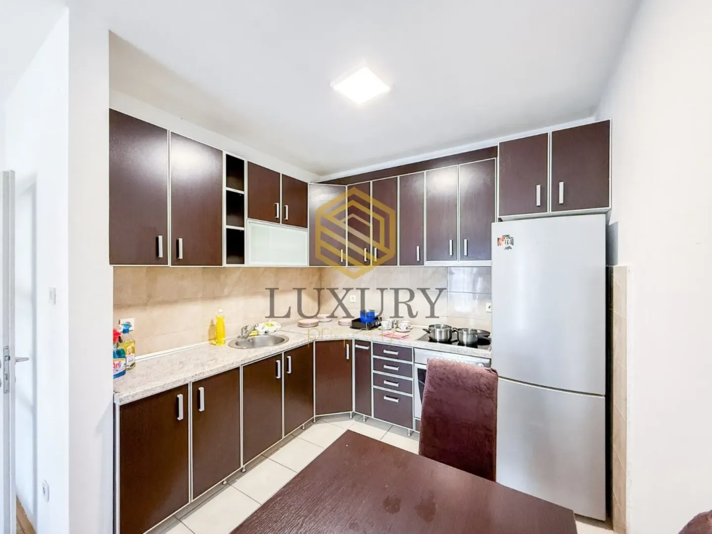 Kitchen equipped with dark cabinetry and a white refrigerator.