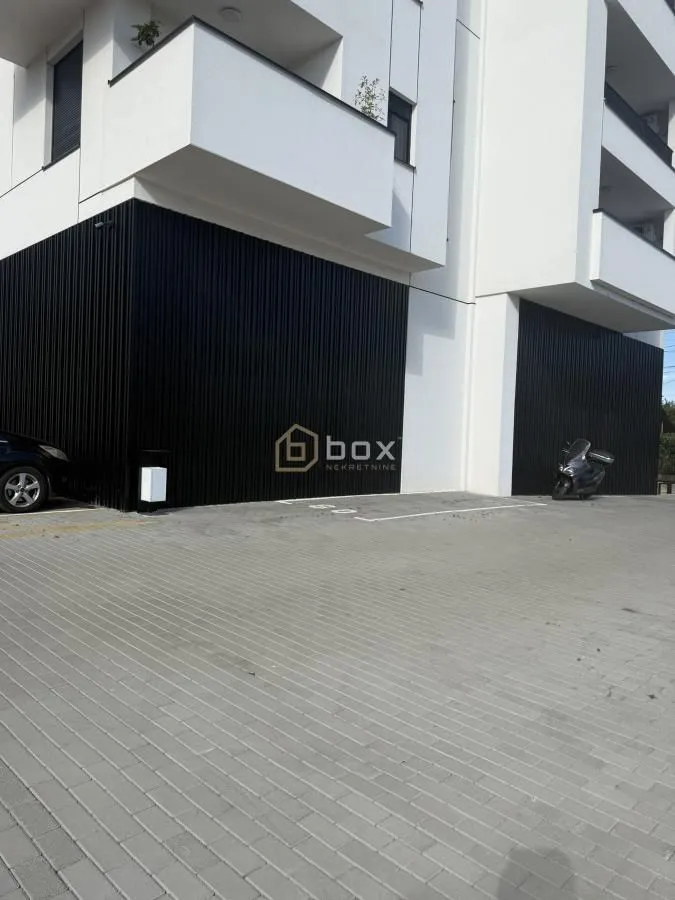 View of the exterior of the building with parking space and entrance.