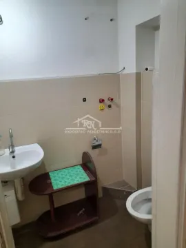 Small bathroom with a sink and toilet in light tiles. - image 3