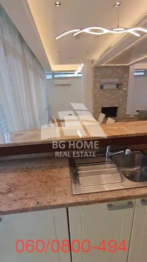 View from the kitchen with countertop and sink towards the living room and dining area.