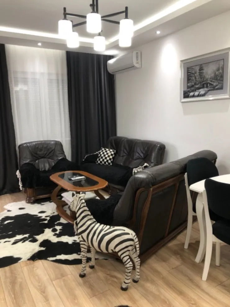 Furnished living room with sofa set and dining table.