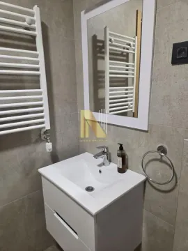 Manje kupatilo sa belim umivaonikom, ogledalom i radijatorom za peškire na sivoj pločici. - image 14