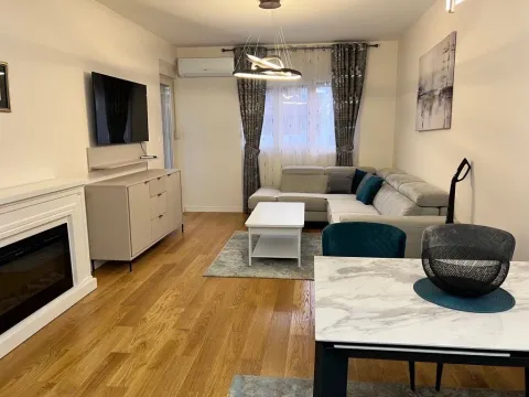 Spacious living room with a sofa set, TV, and dining table. - image 3