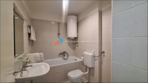 Bathroom equipped with a bathtub, washbasin, toilet, and water heater. - image 13
