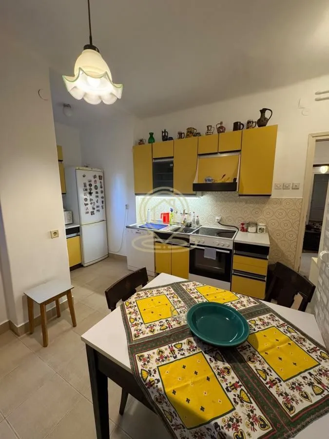 Kitchen with yellow cabinets and a dining table in the foreground.