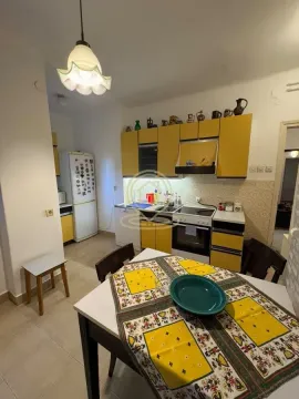 Kitchen with yellow cabinets and a dining table in the foreground. - image 3