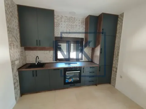 Modern kitchen with dark cabinets, built-in appliances, and a window. - image 13