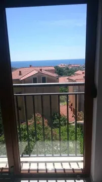 Pogled na more i okolne krovove kroz balkonska vrata. - image 7