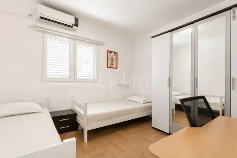 Spavaća soba sa dva kreveta, radnim stolom i velikim ormarom sa ogledalom. - image 4