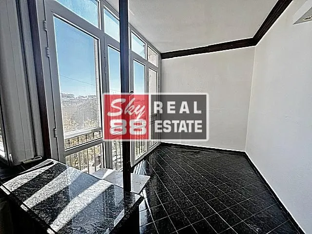 Enclosed terrace with black ceramic tiles and an exterior view.