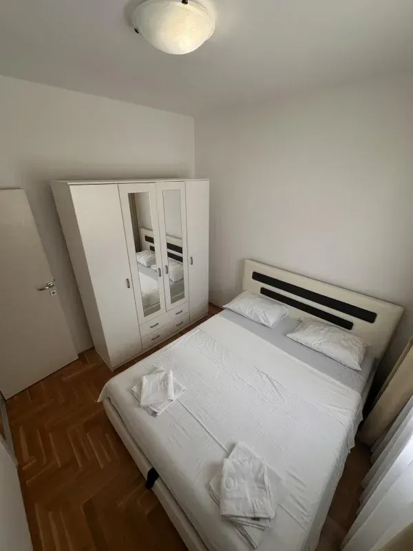 Furnished bedroom with a double bed and a wardrobe.