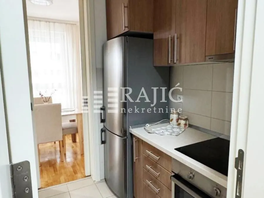 Small kitchen with wooden cabinets and built-in appliances.