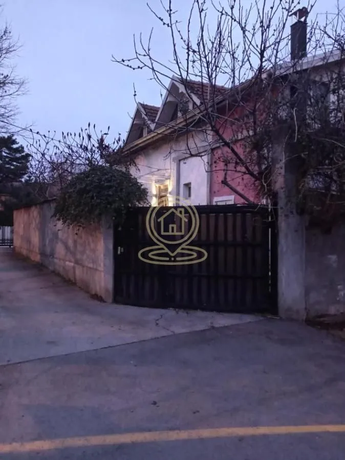 View of the exterior of the house with a courtyard gate and fence.