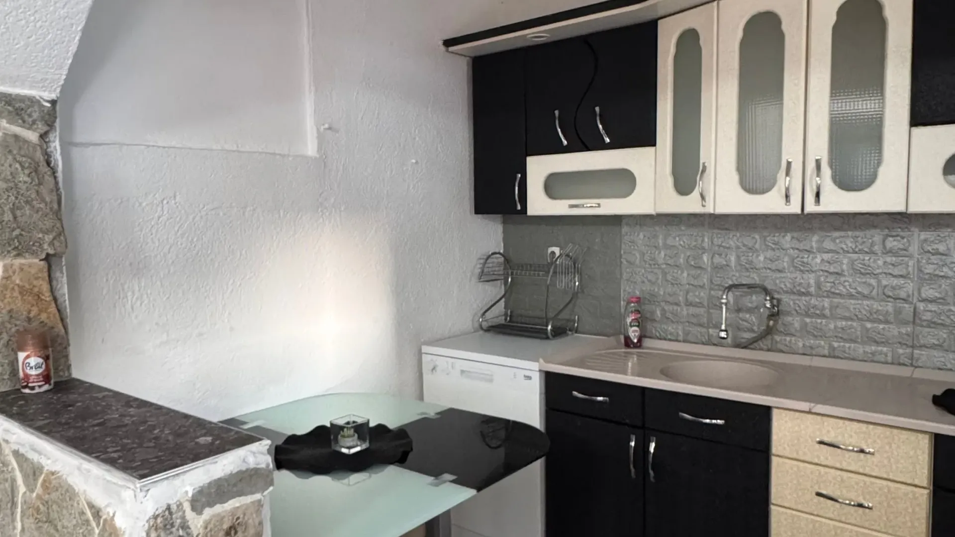 Small kitchen with black and white cabinetry and a dining table.