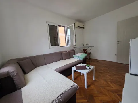 Living room with a sectional sofa, coffee table and a window. - image 7