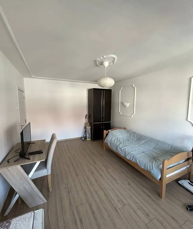 Bedroom with a bed, desk, and wardrobe.