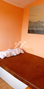 Manja spavaća soba sa krevetom i narandžastim zidovima. - image 5