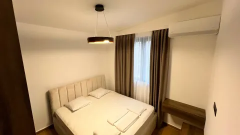 Furnished bedroom with a double bed, curtains, and air conditioning. - image 5