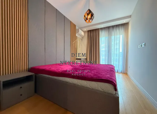 Modern bedroom with a double bed and wooden wall panels.