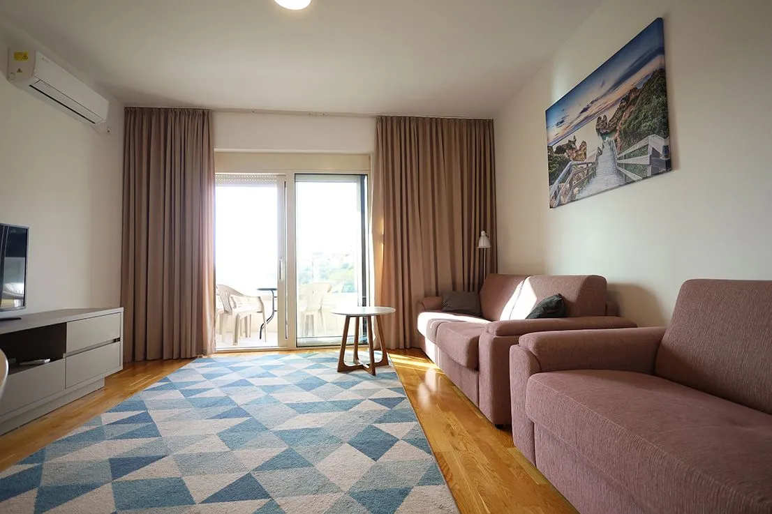 Living room with a sofa set, rug, and access to the terrace.