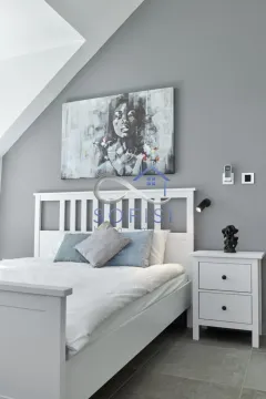 Modern bedroom with a white bed and an artwork on the wall. - image 14