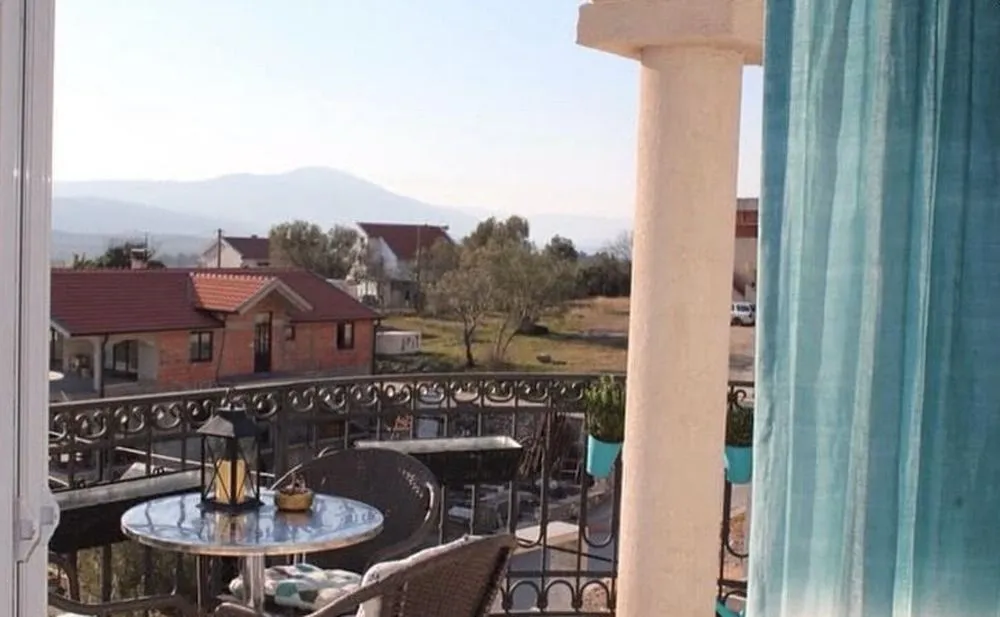 Furnished terrace with a table, chairs, and a view of the surroundings.