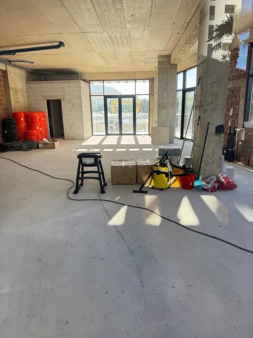 View of a spacious room under construction with building materials and tools.