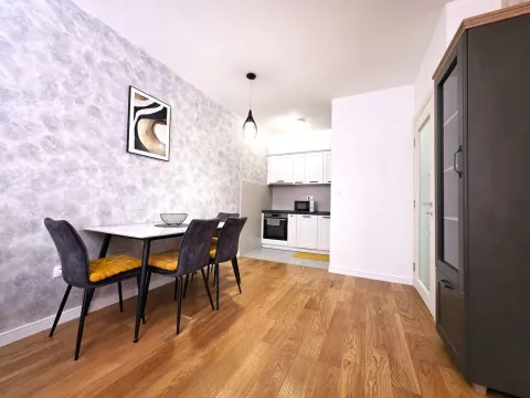 Dining area with a table and chairs, and a view of the kitchen in the background. - image 4
