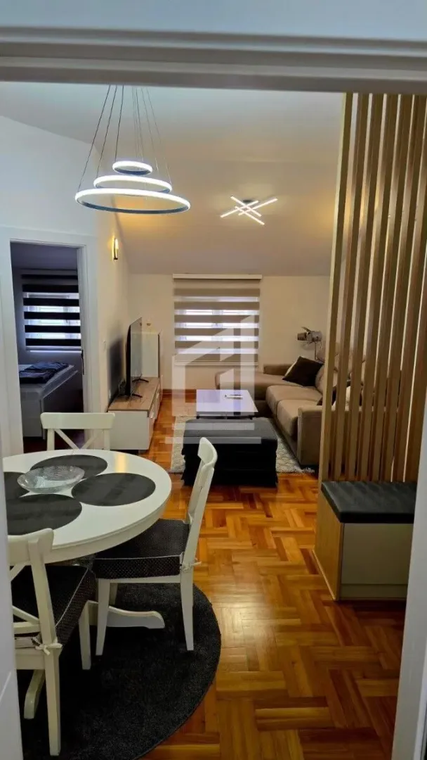 Living room with a dining area and parquet flooring.