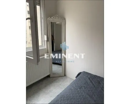Small bedroom with a bed, a mirror, and a window. - image 6
