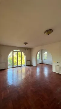 Empty spacious room with parquet flooring and arched windows. - image 5