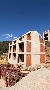 Pogled na stambeni objekat u izgradnji sa građevinskim materijalom u dvorištu. - image 2